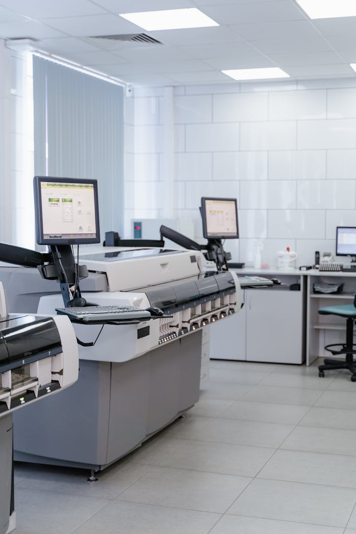 Bright and organized laboratory featuring high-tech printers and workstations.